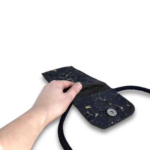 KEDJA deluxe Umhängetasche in anthrazit-schwarz mit Sicht auf das geöffnete Fach und Hand, ideal für Motorola Moto E14