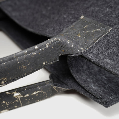 Detailaufnahme eines schwarzen Korkgriffs mit sichtbarer Struktur an einer Filz Shopper Tasche, nachhaltige Materialien