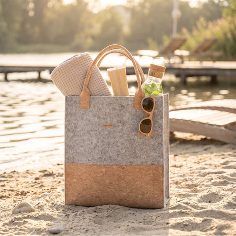Filz Shopper Tasche in Hellgrau mit naturfarbenem Kork am Strand, nachhaltige Tasche im minimalistischen Sommerlook
